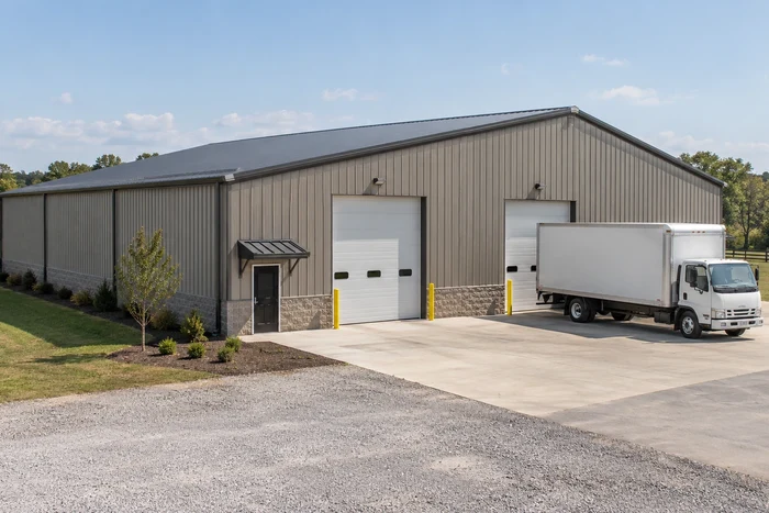 Warehouse storage building with grade-level loading doors and a box-truck approach. Warehouse storage building with grade-level loading doors and a box-truck approach.