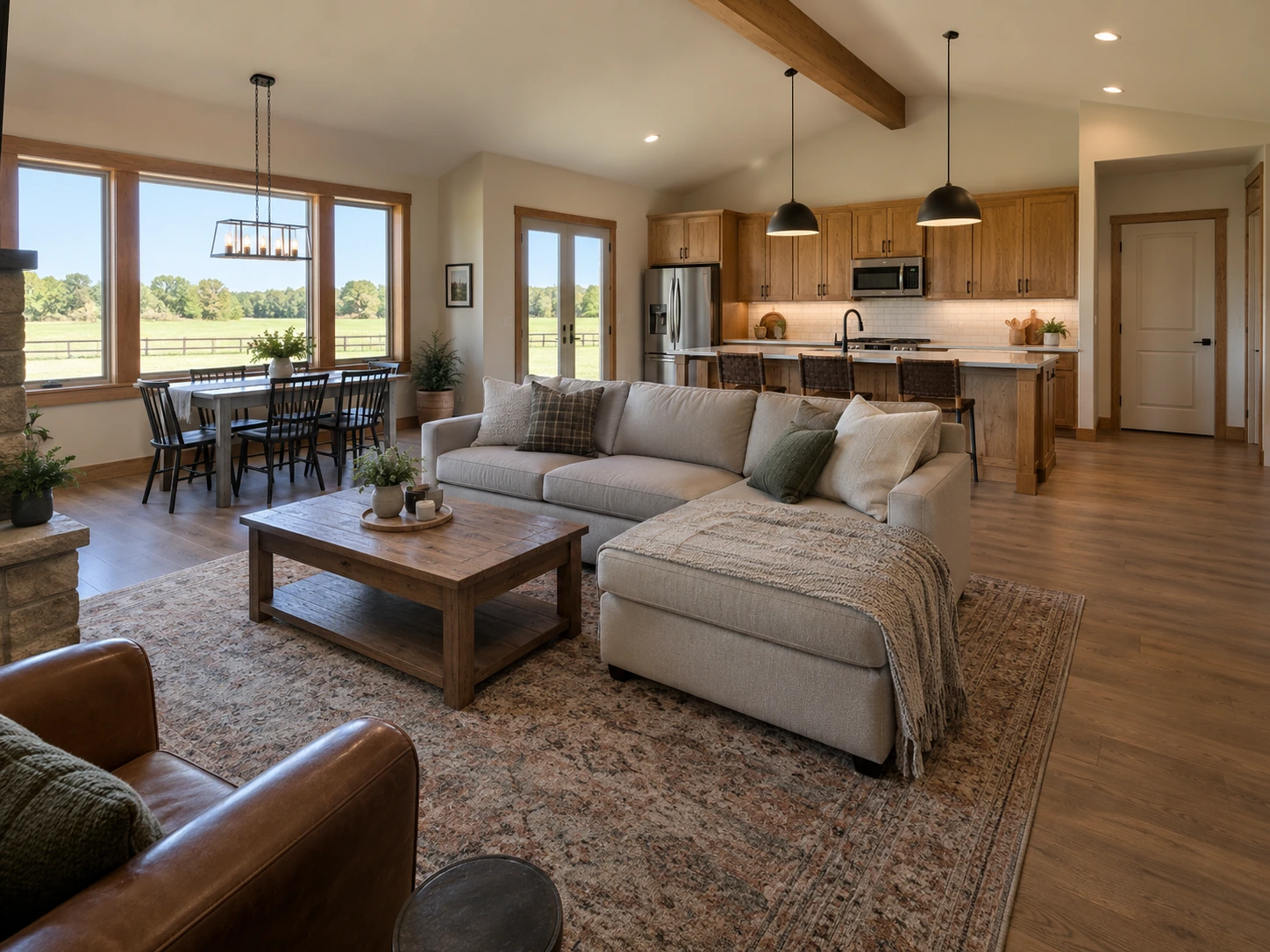 Barndominium living area with an open kitchen, dining space, and pasture-facing windows.
